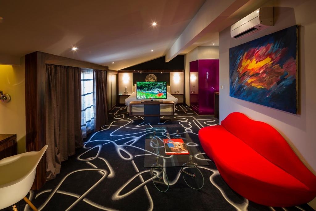 图卢兹布列讷酒店的客厅配有红色沙发和电视