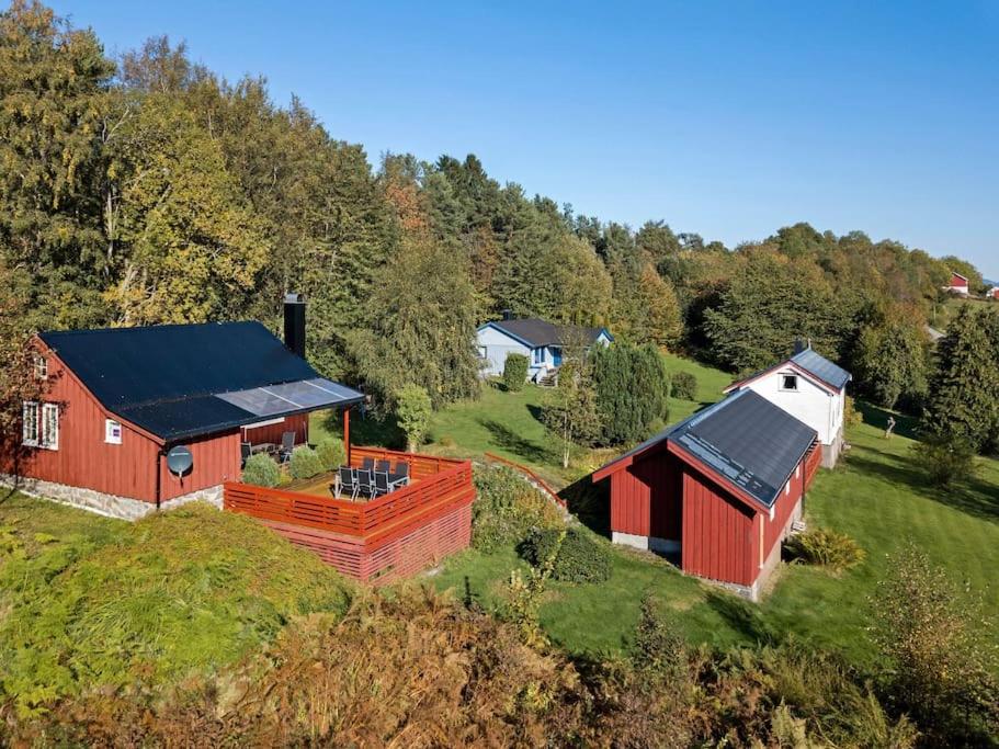 ÅrøyFeriehus nær badeplass og Molde sentrum的山坡上带黑色屋顶的红色谷仓