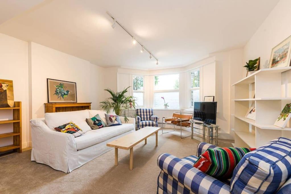 伦敦Spacious 2 bed Garden Flat by the Thames+parking的客厅配有两张沙发和一台电视机