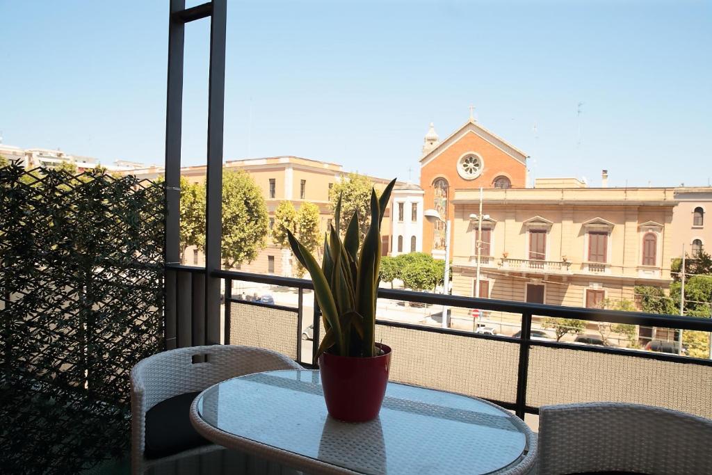 巴里L.T. Savoia Palace & Cavour C.L.的坐在阳台上桌子上的盆栽植物