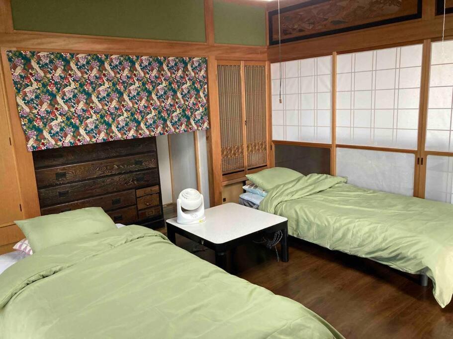 高知桂浜龍馬に1番近い宿ペットと泊れる一軒家龍馬庵的一间设有两张床和一张桌子的房间