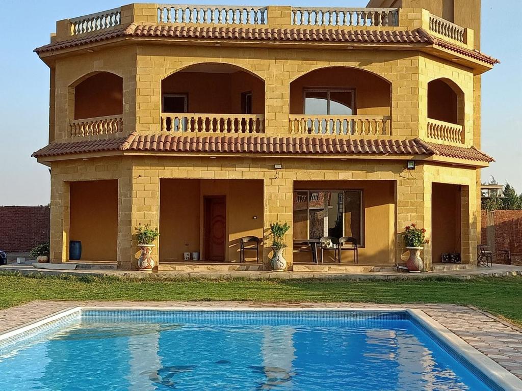 El-Qaṭṭaفيلا للايجار في كمبوند سمر قند的一座房子前面设有游泳池