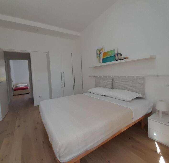 佩萨罗Casacciuga, luminosa e centrale casa con giardino的白色卧室设有一张大床和木地板