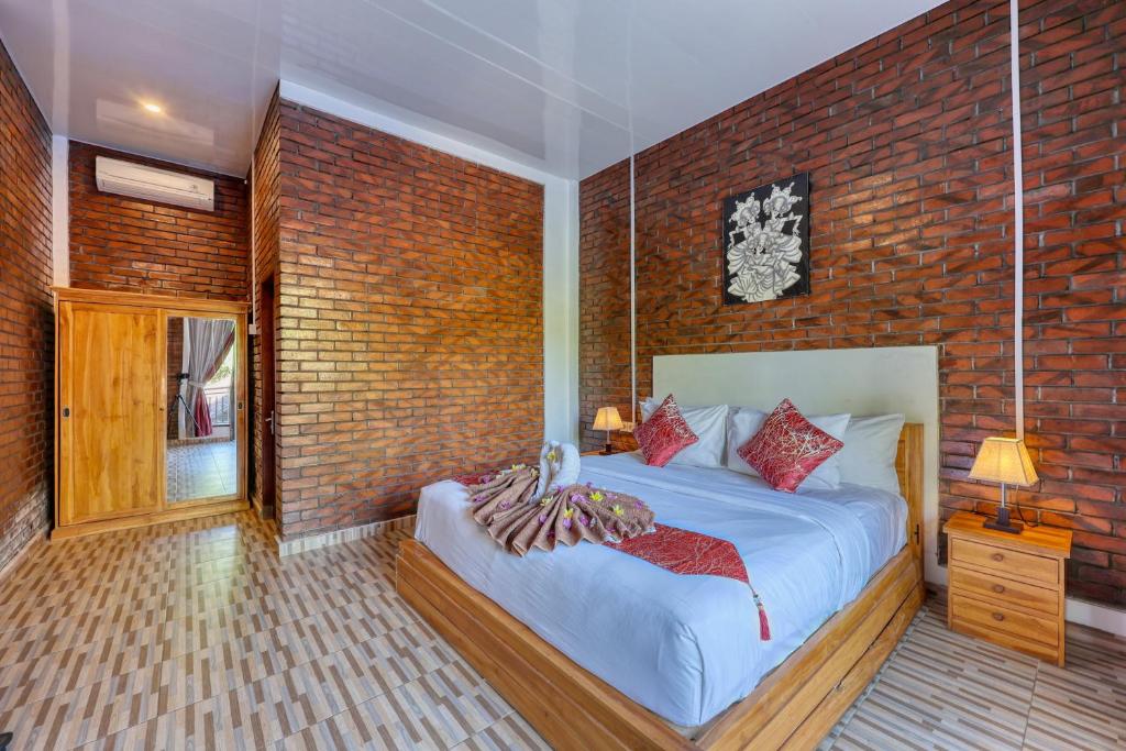 珀尼达岛Dyou Villa的一间卧室设有一张床和砖墙