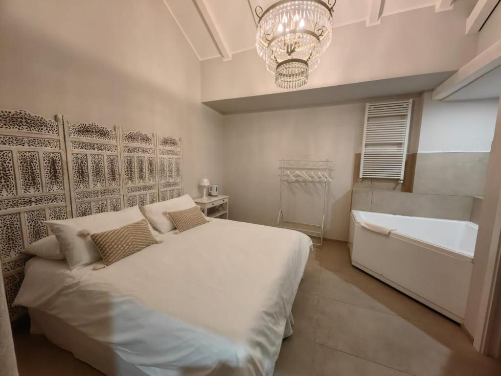 科尔马诺迪伊布拉维B&B酒店的一间卧室配有一张床、一个浴缸和一个吊灯。