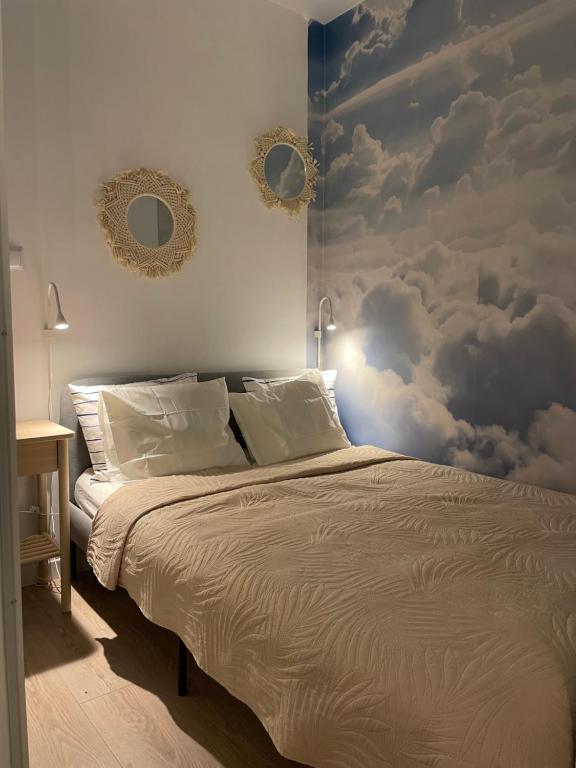 弗罗茨瓦夫LeHome Airport Wroclaw的卧室配有一张墙壁上云彩的床