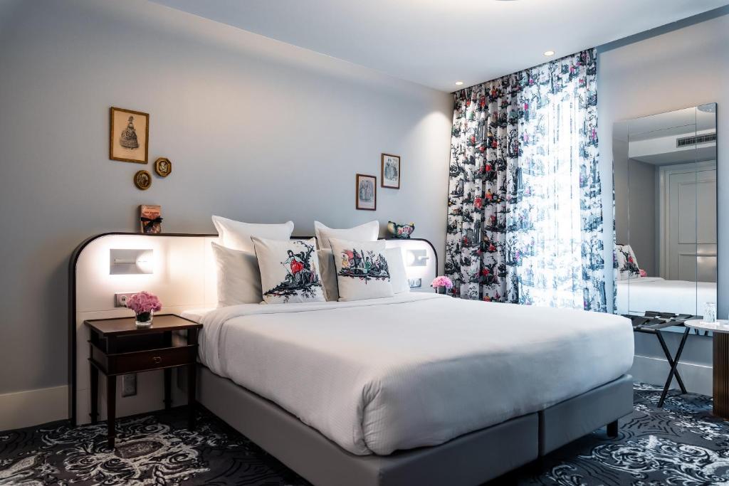 巴黎Normandy Le Chantier的一间卧室设有一张大床和一个窗户。