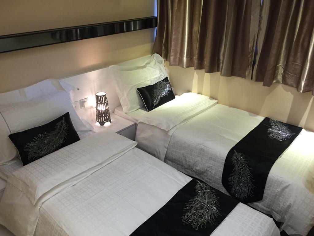 香港季节酒店 - 铜锣湾的一间带三张床的卧室,配有白色床单