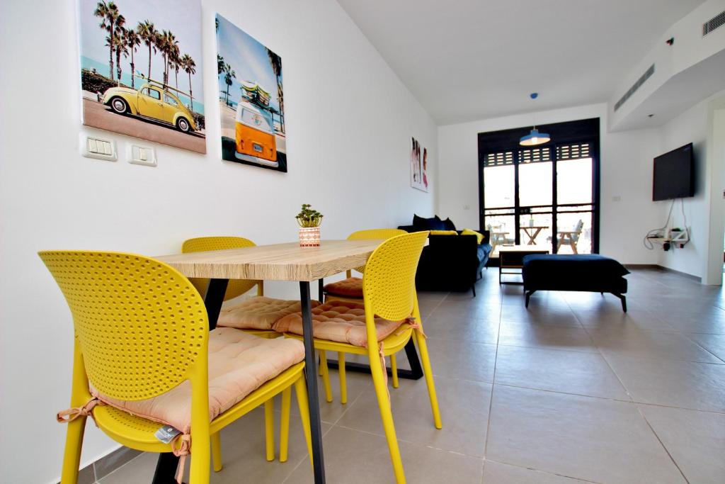 特拉维夫beautiful 2 bedrooms apartment with balcony的一间带桌子和黄色椅子的用餐室