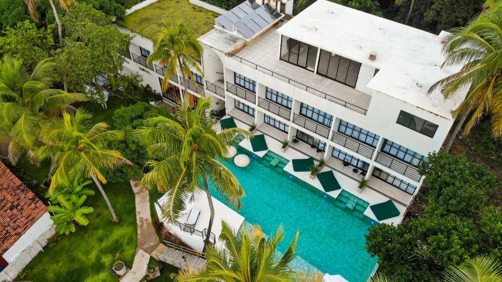 雅帕拉廷加Milie Lounge Pousada的享有带游泳池的建筑的空中景致