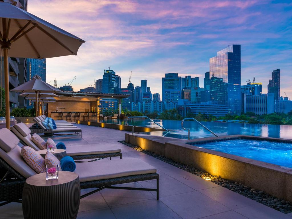 马尼拉普利米亚探索酒店的一个带游泳池和城市天际线的屋顶露台