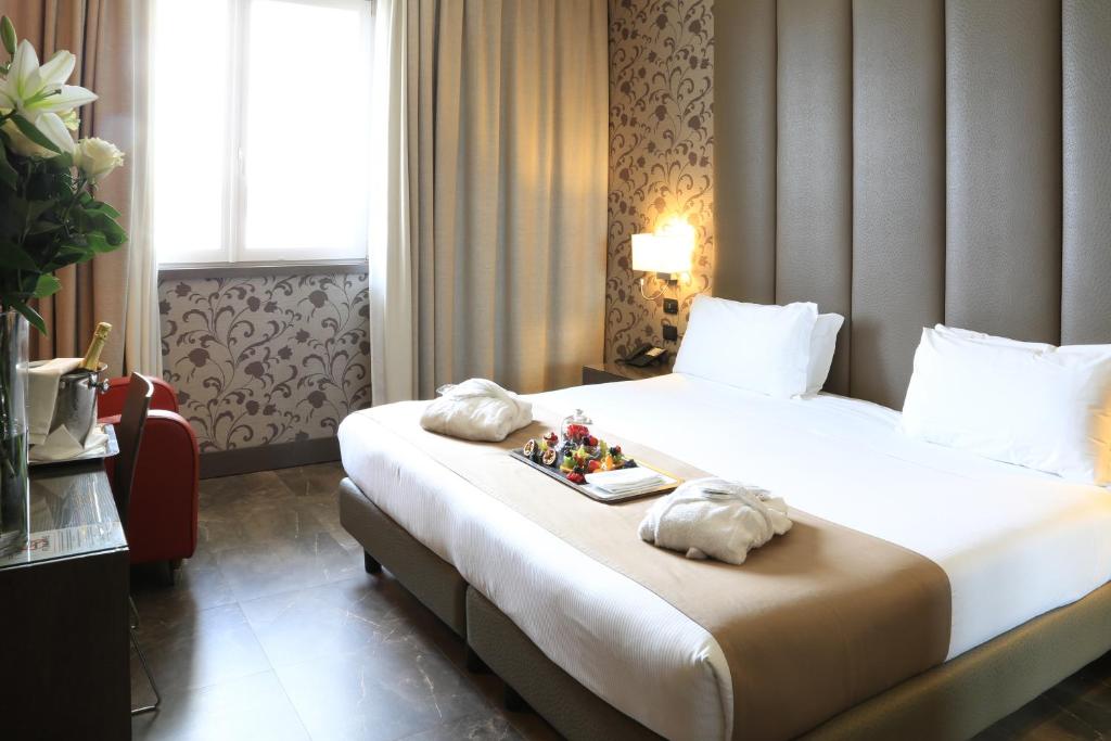 米兰米兰展会克利马酒店的一间酒店客房,配有一张床铺,上面放着一个食物托盘