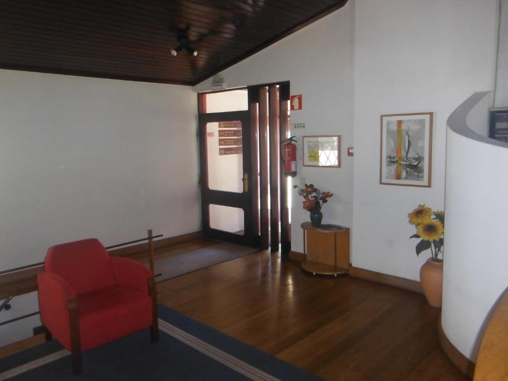 旧阿尔贝加里亚Hotel Alameda的客厅配有红色椅子和门