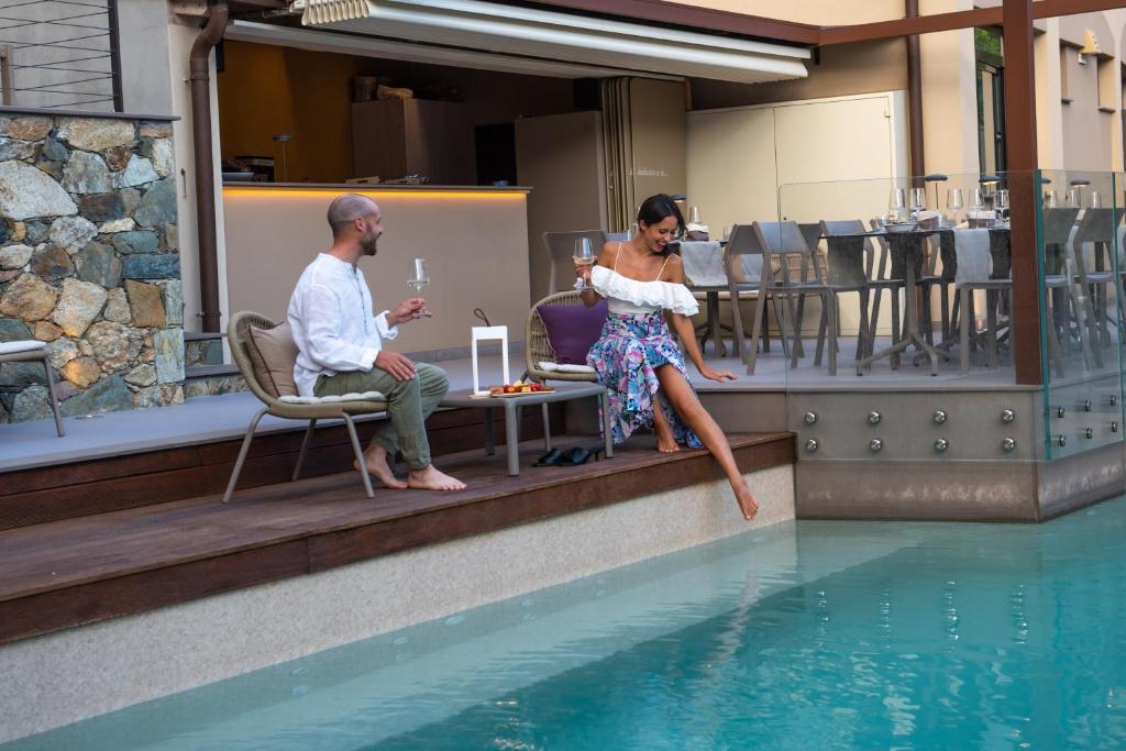 瓦拉泽苏里高酒店的坐在游泳池旁的男人和女人