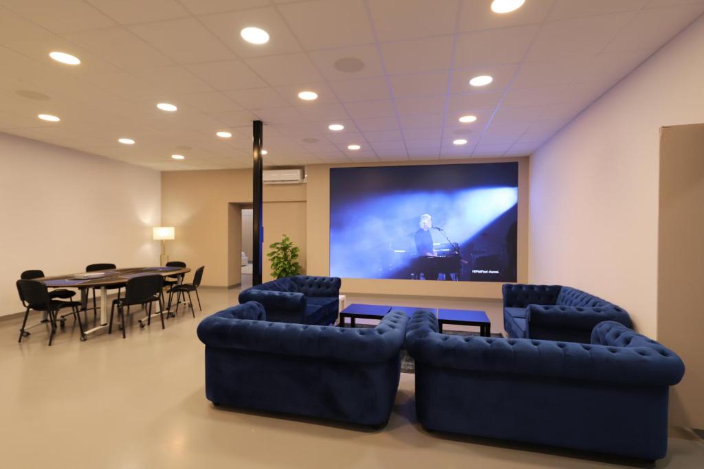 马赛Loft 250m2 avec écran led géant de 10m2的配有投影屏幕和桌椅的房间