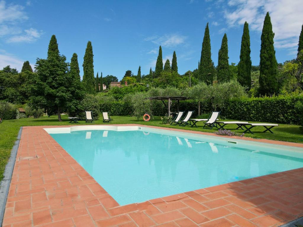 卢卡Agriturismo Mansi Bernardini的庭院内的游泳池,带椅子和树木