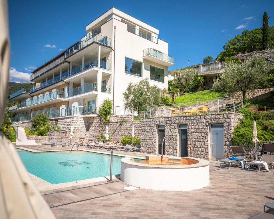 加尔达湖滨Hotel Benacus Panoramic的建筑前的一座带游泳池的建筑