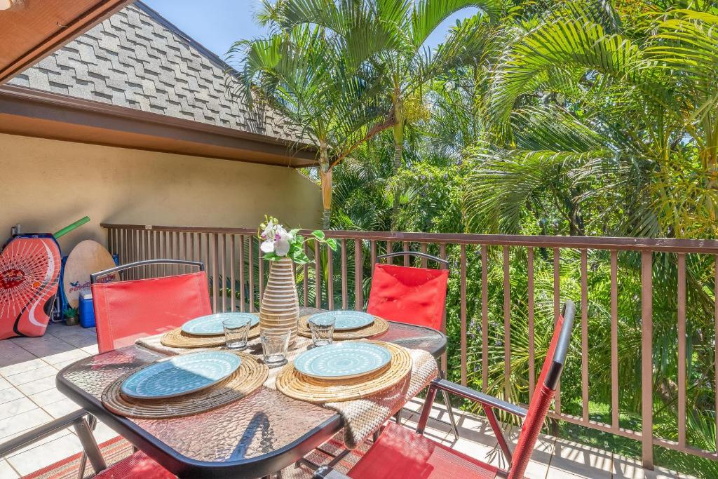 基黑Koa Resort 3J的棕榈树阳台的桌椅