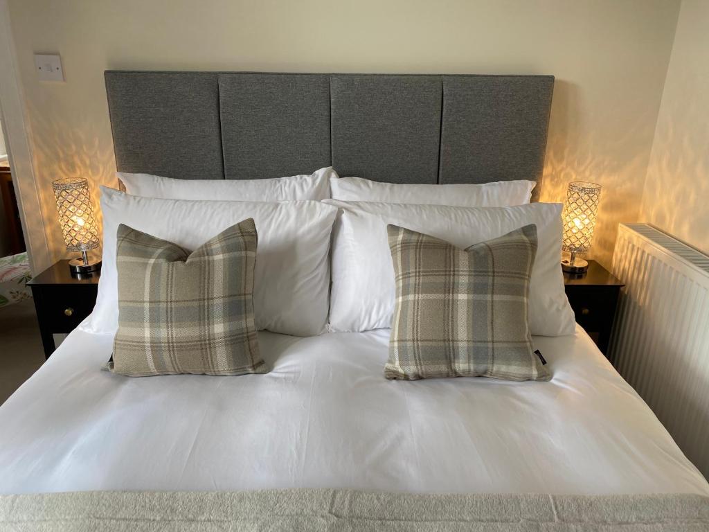 爱丁堡Tranquil Haven Murrayfield的一张带两个枕头和床头板的白色床