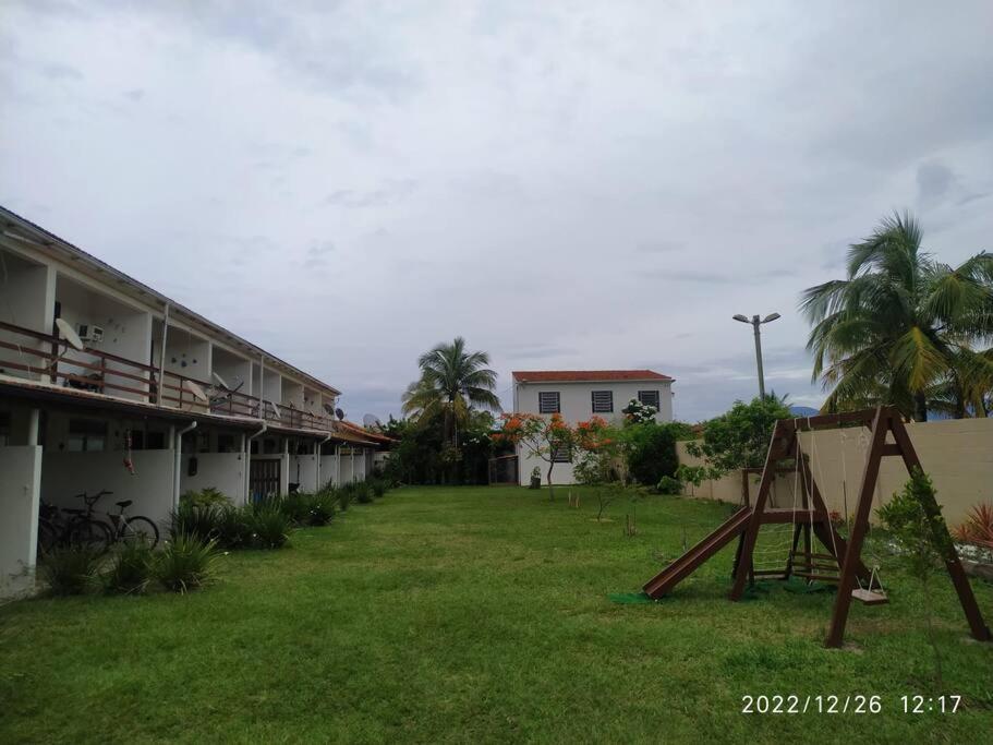 萨夸雷马Casa em Condomínio tranquilo bem perto da praia!的一座带游乐场的建筑前的院子