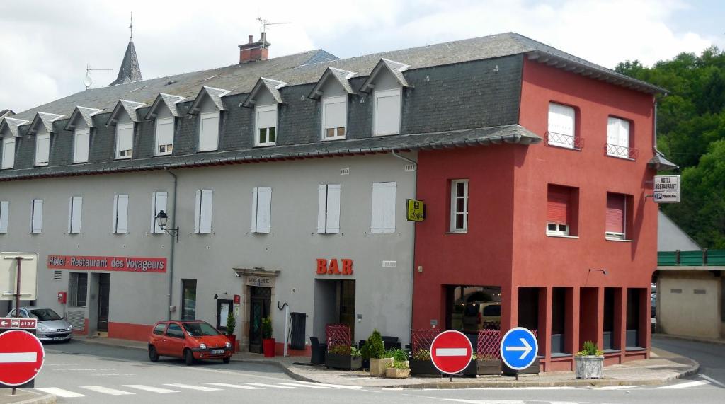蓬德萨拉尔旅行者国际之家酒店的街道上一座红白色的建筑,有路标