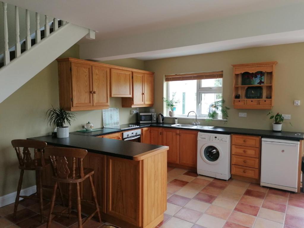 科克Radharc Na Greine的厨房配有木制橱柜、水槽和洗碗机。