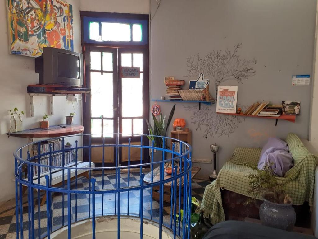罗萨里奥Coolraul Hostel的客厅配有蓝色圆桌和沙发
