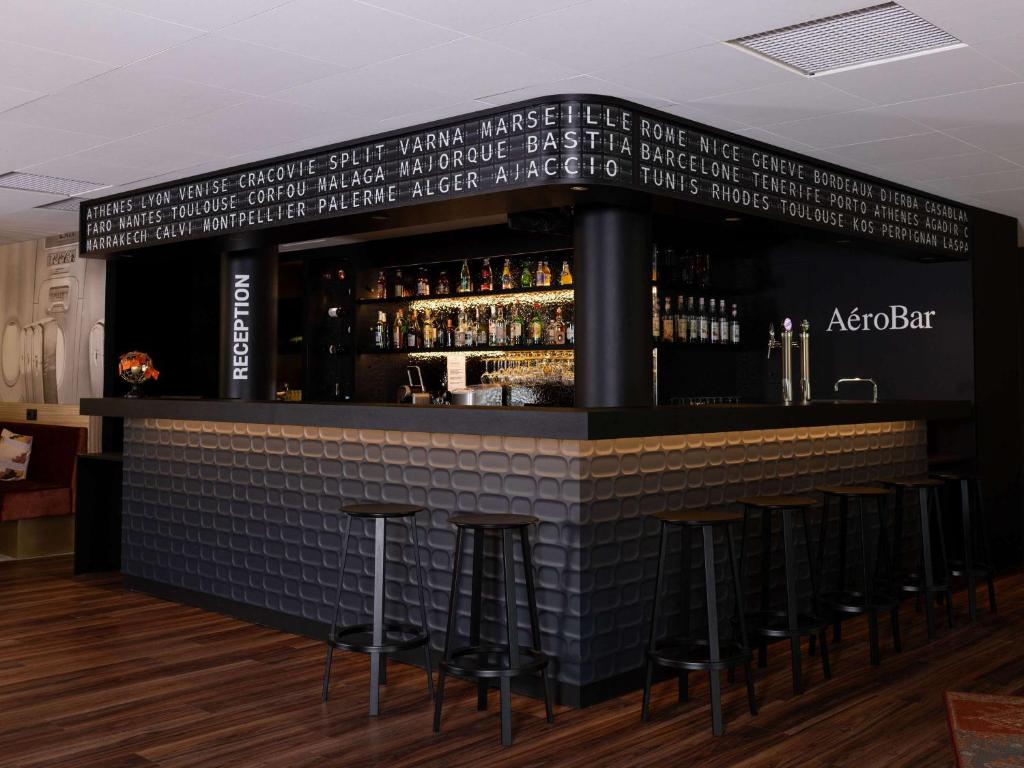 莱斯坎四季里尔机场酒店的砖墙前有凳子的酒吧