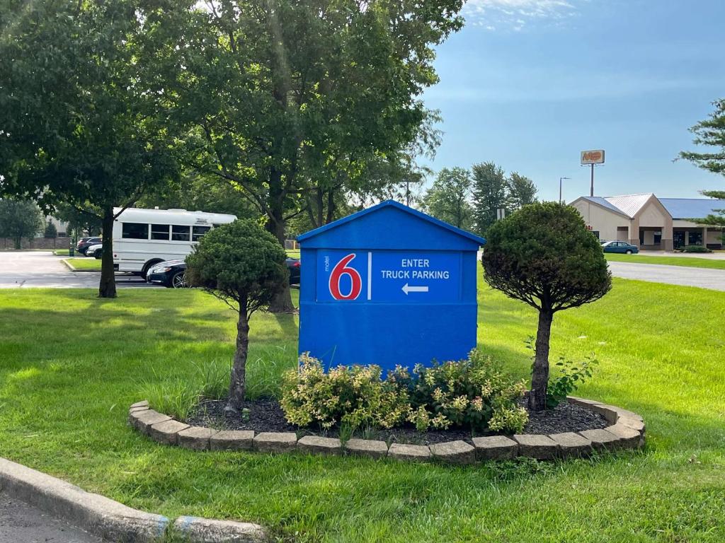 拉法叶Motel 6-Lafayette, IN的草上的一个蓝色标志,两棵树