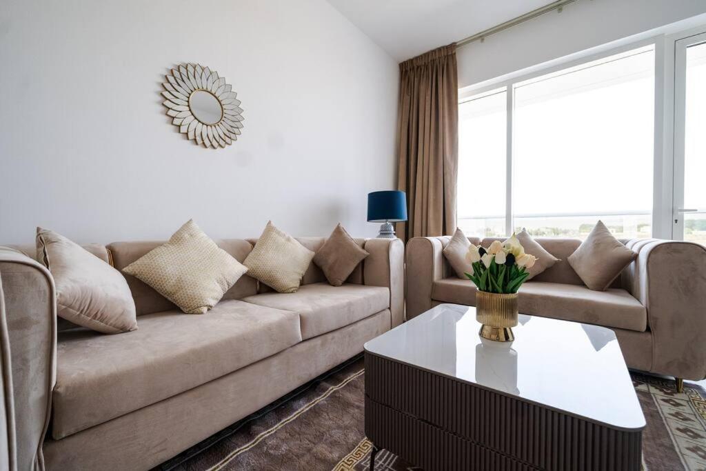 迪拜Elegant 2BR near Palm Jumeirah - 6 Min Drive的客厅配有沙发和桌子