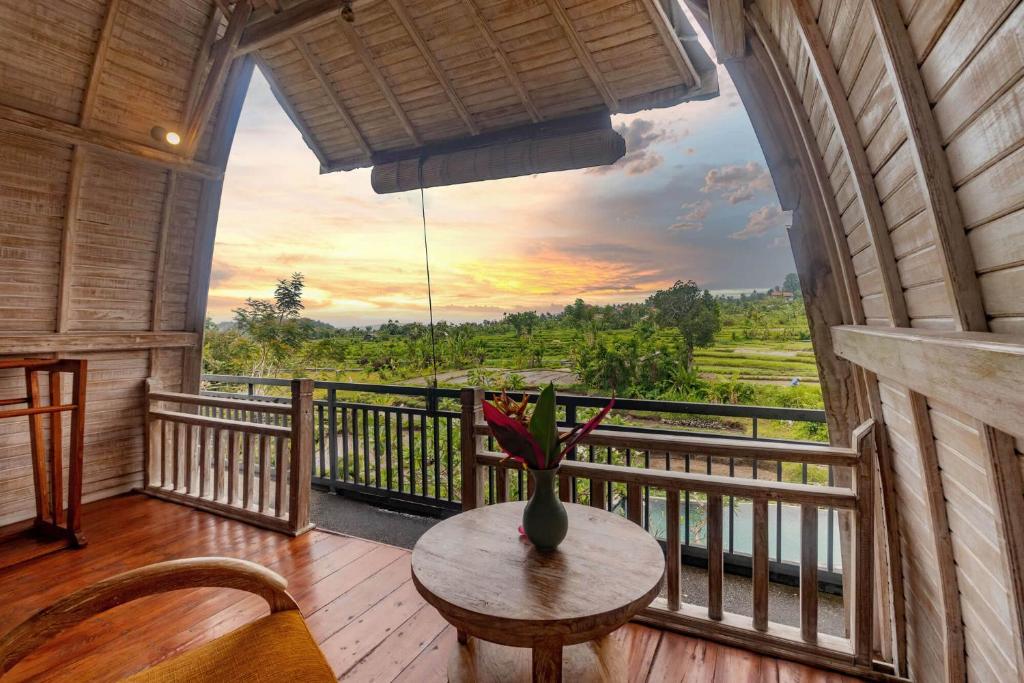 TirtaganggaAlamGangga Villas Tirta Gangga的客房设有一张桌子和一个美景阳台。