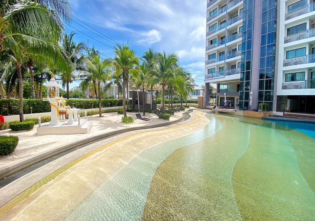乔木提恩海滩Laguna Beach Resort 1 Condominium的棕榈树建筑前的游泳池
