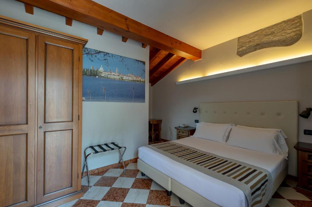 曼托瓦阿卡萨棣冈萨加酒店的一间卧室设有一张大床和一个窗户。