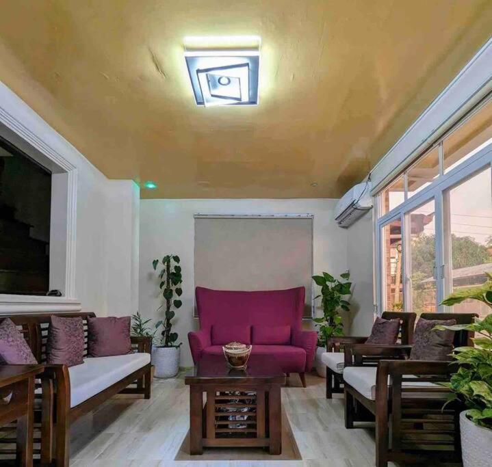 巴旺Discover the charm of this homely villa just a stone's throw from the beach的客厅配有紫色的沙发和桌子