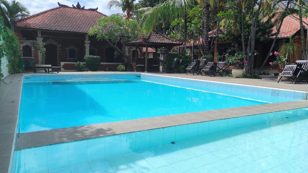 罗威那Keyani Bungalows Lovina的一座大蓝色游泳池,位于房子前