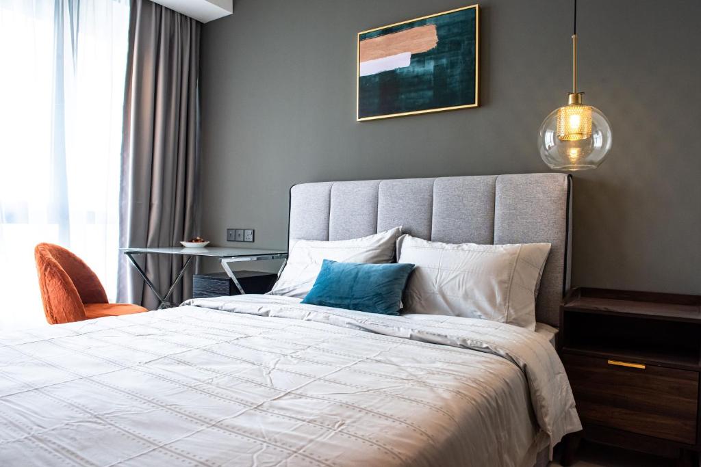吉隆坡Stay @ NOVO Ampang的一间卧室配有一张带蓝色枕头的床