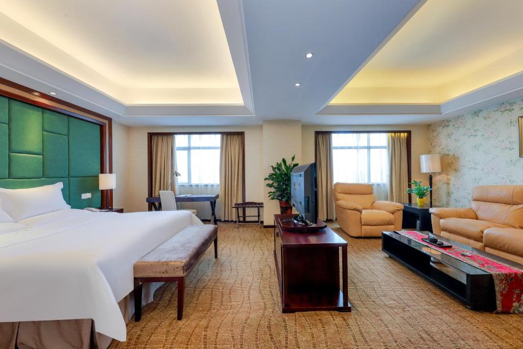 郑州郑州粤海酒店的一间带大床的卧室和一间客厅