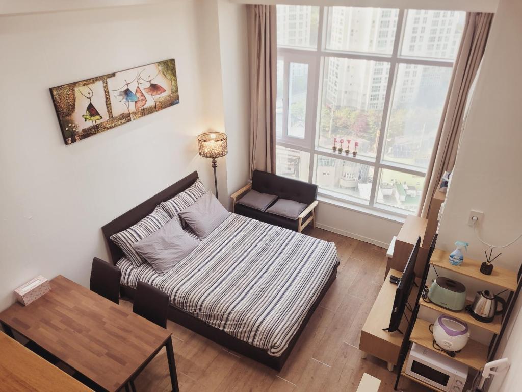 首尔旅行者之家酒店的一个小客厅,配有一张床和一张桌子
