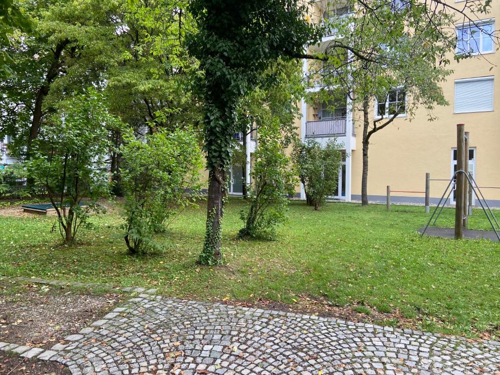 慕尼黑Bayern Lodge München的一座公园,在一座建筑前有树木