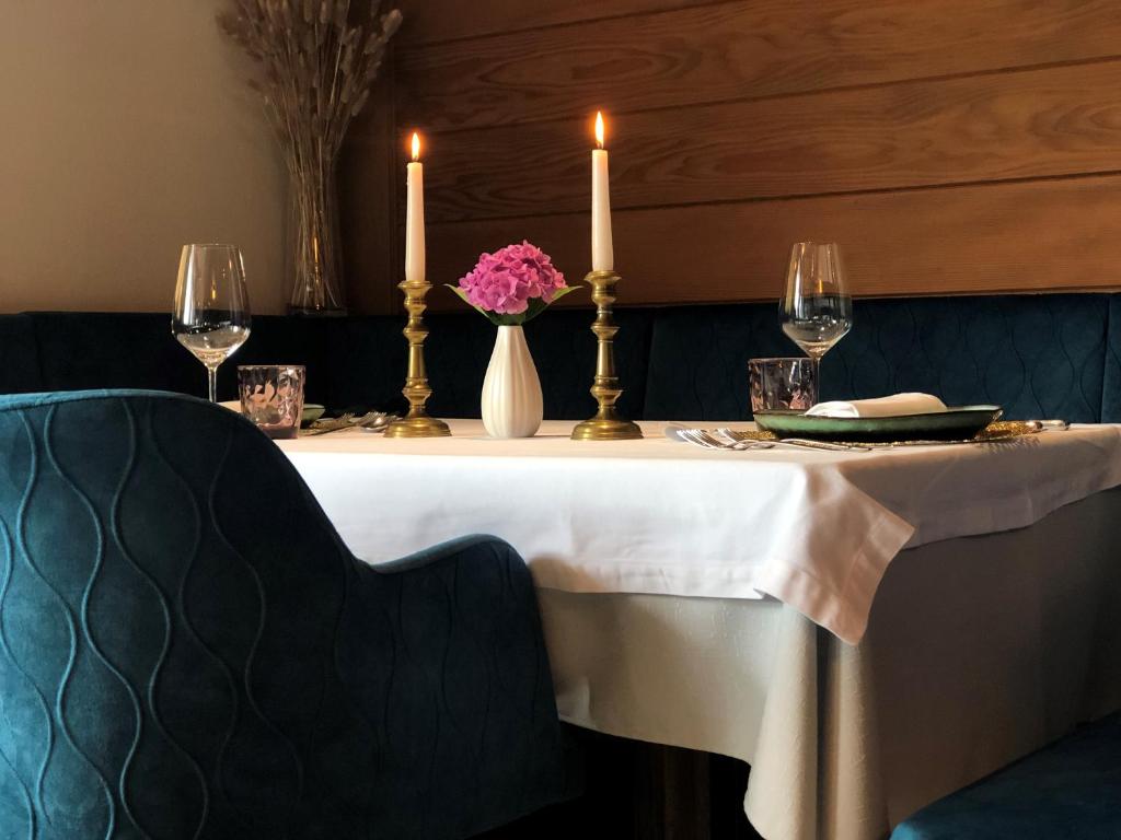 摩梭Hotel Alpenland的一张桌子,上面有两根蜡烛和花瓶