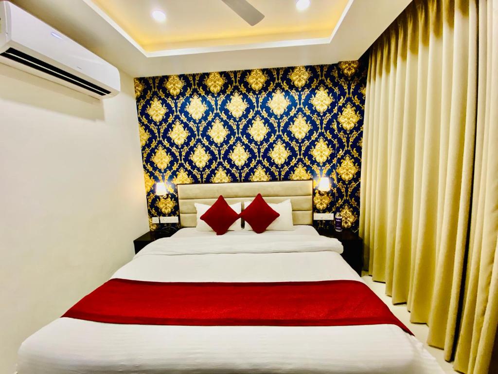 钱德加尔Blueberry Hotel zirakpur-A Family hotel with spacious and hygenic rooms的一间卧室配有一张带红色枕头的大床