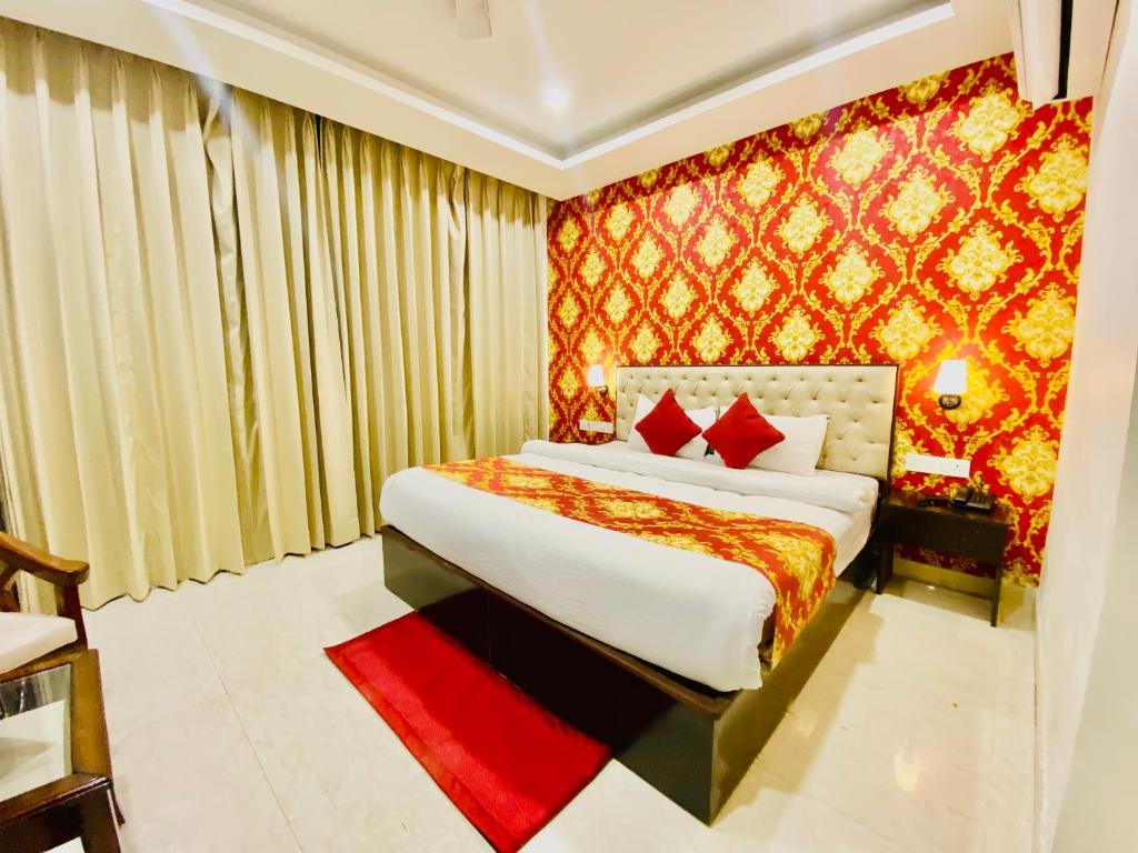 钱德加尔Blueberry Hotel zirakpur-A Family hotel with spacious and hygenic rooms的一间卧室设有一张床和红色的墙壁