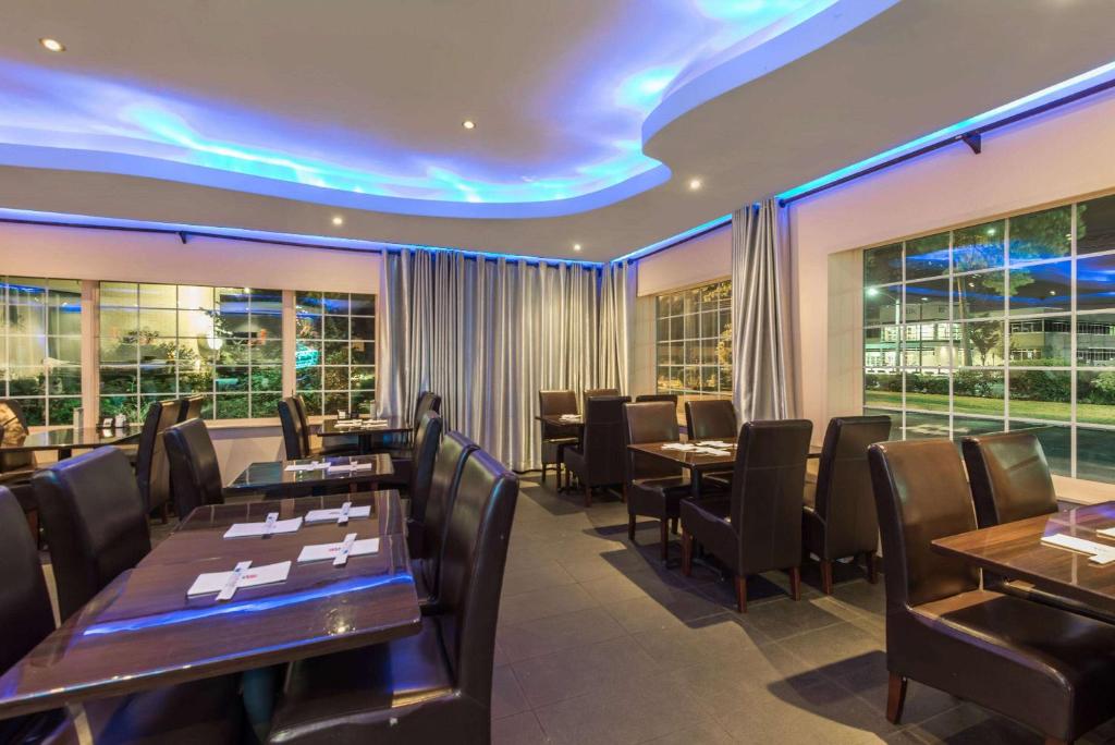 希克斯维尔希克斯维尔戴斯酒店-长岛的餐厅设有桌椅和窗户。