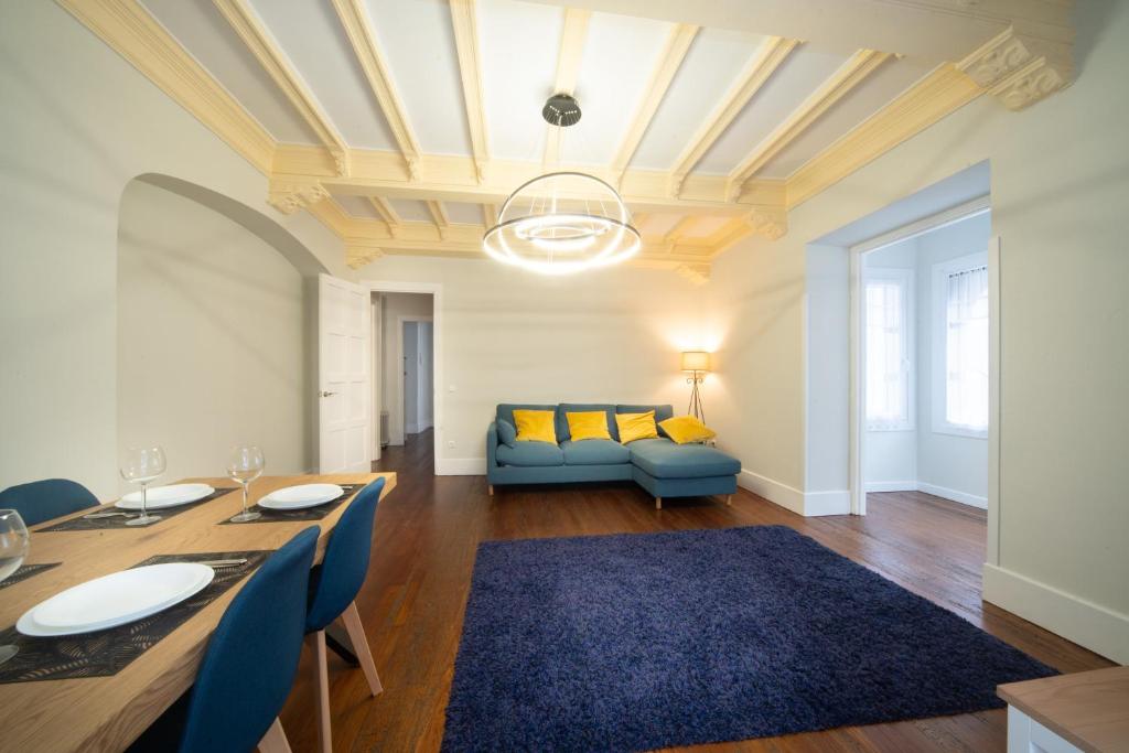 扎马亚Apartamento con garaje en el centro de Zumaia的客厅配有桌子和蓝色沙发