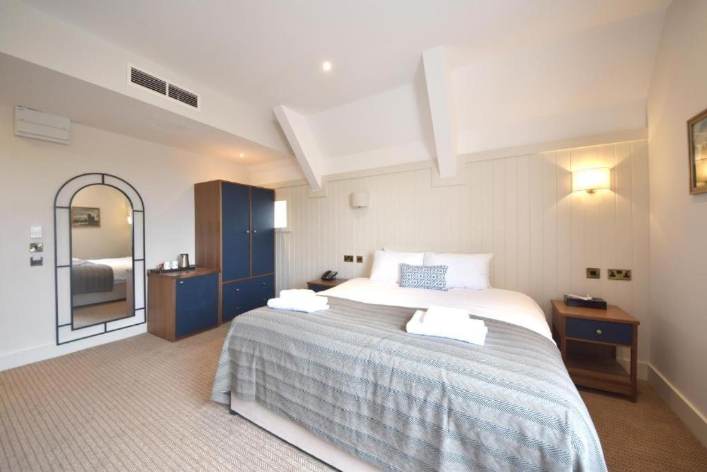 法恩伯勒埃尔夫瑟姆酒店的一间卧室配有一张大床和镜子