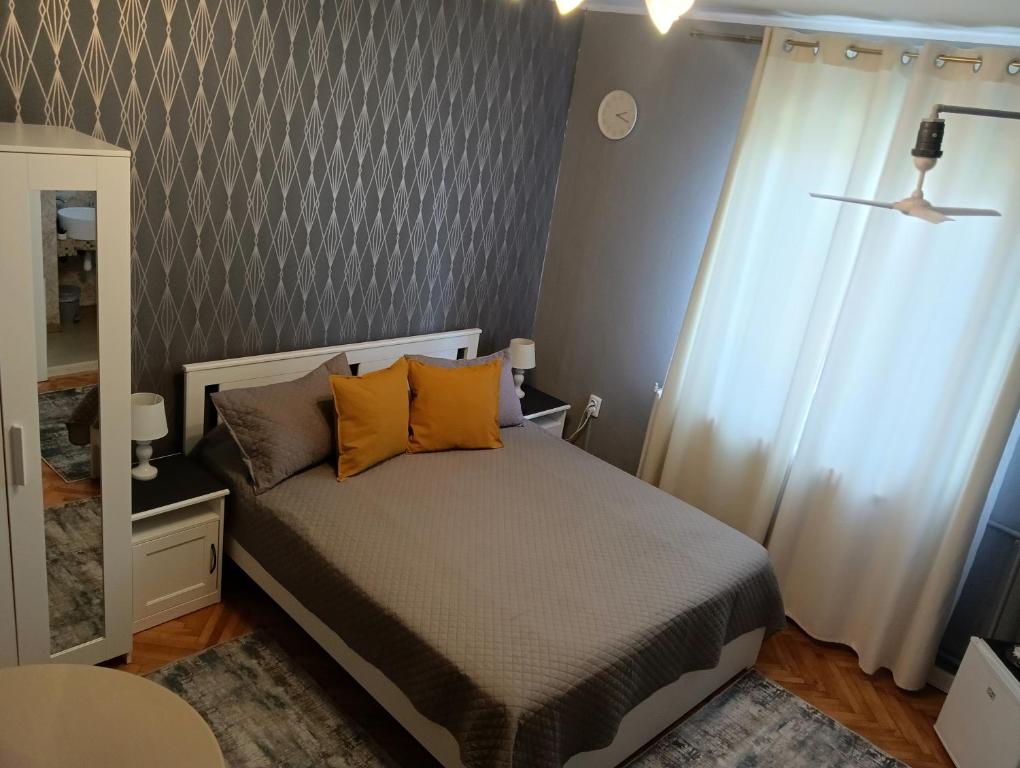 蒂米什瓦拉Crystal Room的一间卧室配有带橙色枕头和镜子的床