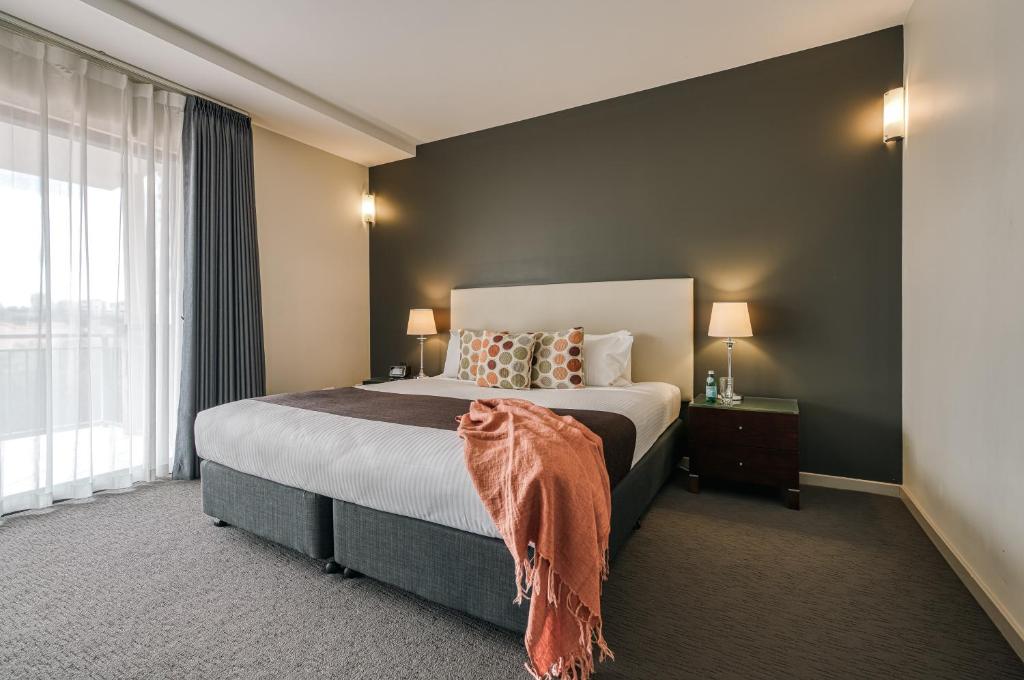 布里斯班伊尔盟多精品酒店的一间卧室设有一张床和一个大窗户
