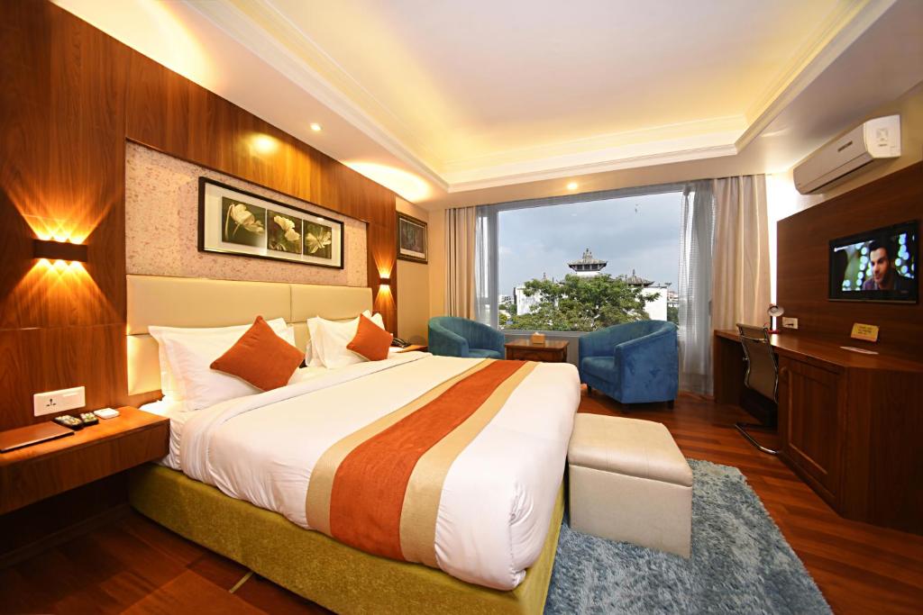 加德满都Kumari Boutique Hotel的酒店客房设有一张大床和一台电视。