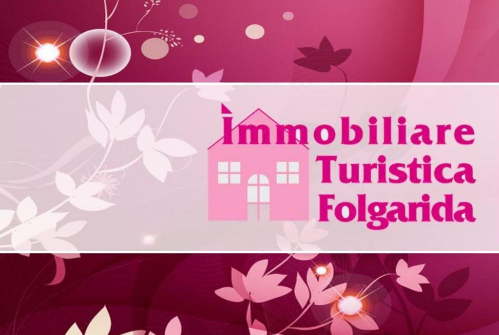 佛加里达Immobiliare Folgarida Apartments的一个带粉红色房子和鲜花的横幅