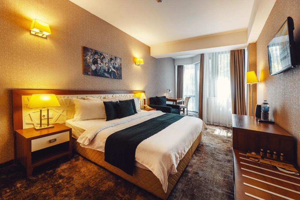 第比利斯考斯特酒店的酒店客房设有一张大床和一张书桌。